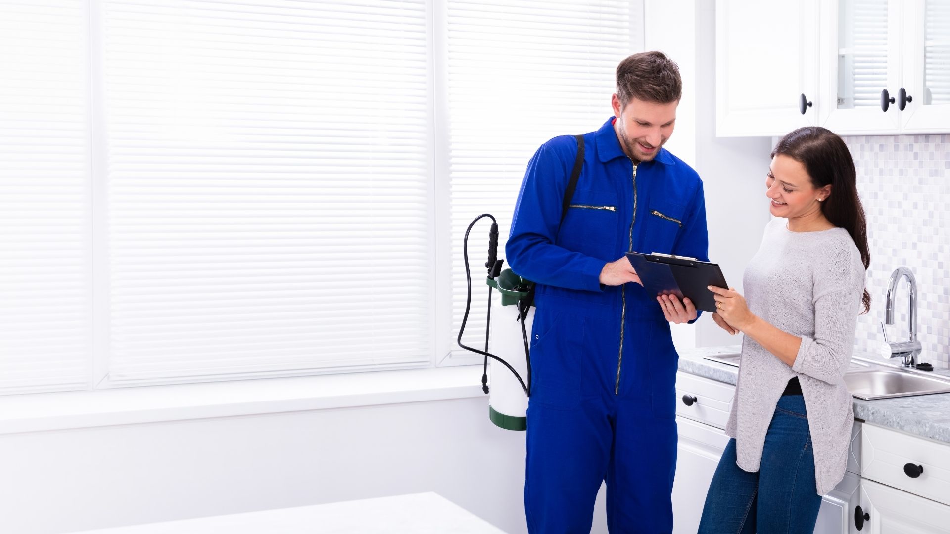 Professional pest control technician inspecting a home with homeowner